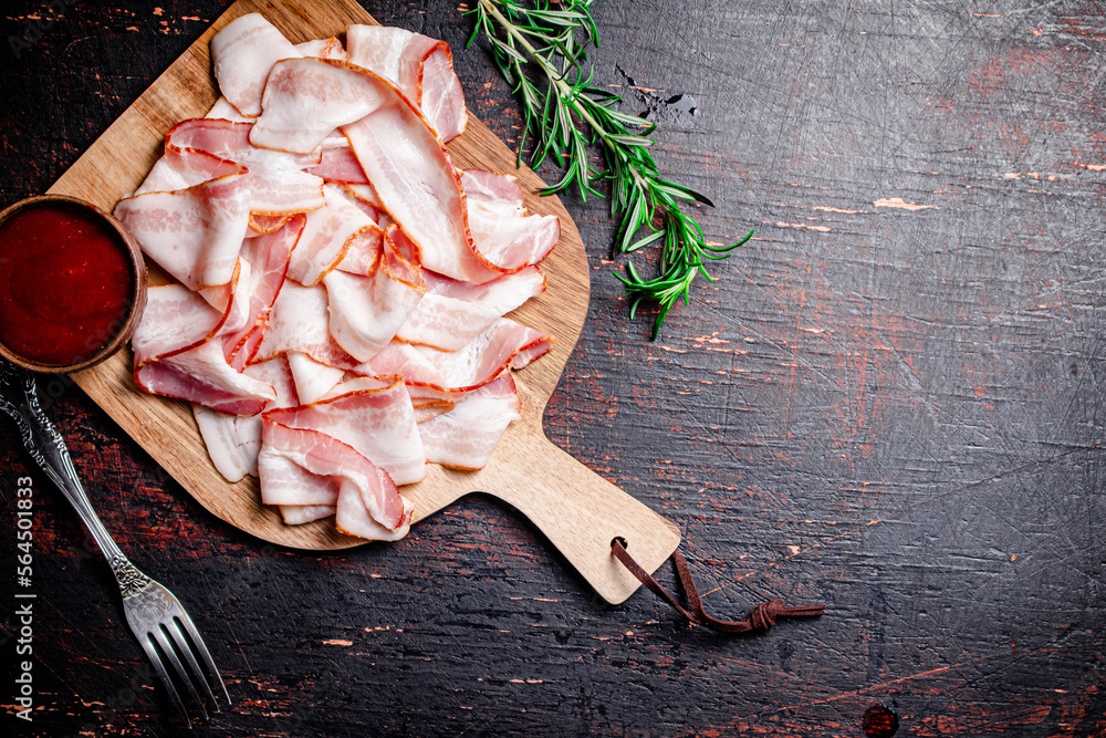 Canvas Prints Pieces of bacon on a cutting board with tomato sauce.