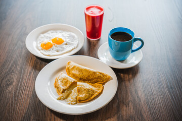 Empanadas de queso, huevos, café y jugo de mora. Comida ecuatoriana.