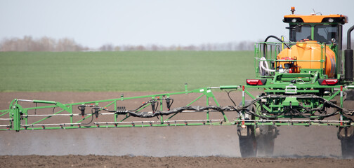 The tractor treats the soil with pesticides.