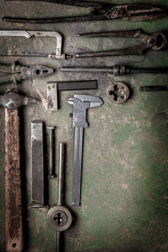 grungy old metalwork tools on stained table background (processing cross-process) 