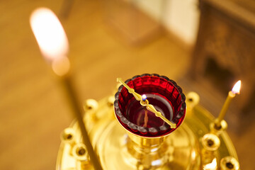 candles and a red lamp with oil and a burning wick on a church candlestick