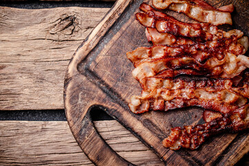 Fried bacon on a cutting board. 
