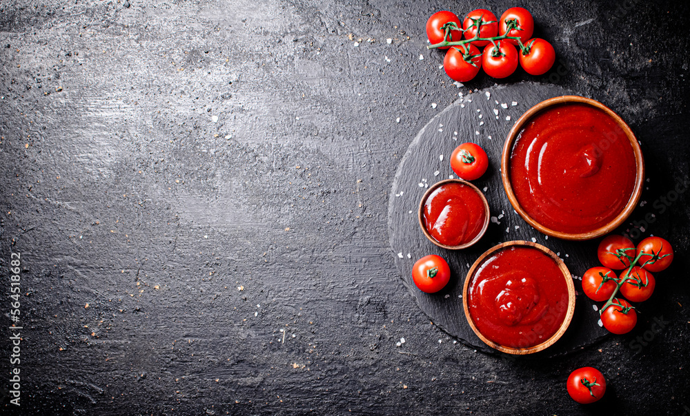 Canvas Prints Tomato sauce in a wooden plate on a stone board with salt. 