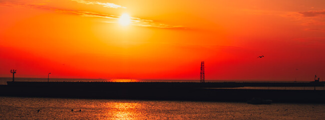 Reflection of sunlight over sea surface at sunset. Orange and gold blue sky. Dramatic Yellow sun...