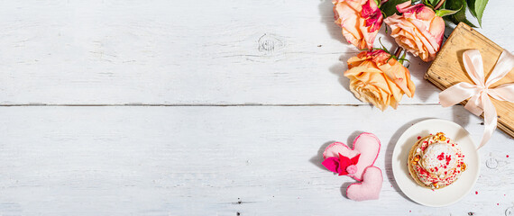 Fototapeta na wymiar The concept of romantic gift. French Shu cake, hibiscus tea, bouquet of roses, festive decor