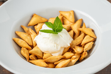 Deep fried crunchy Turkish ravioli or manti on a white porcelain plate