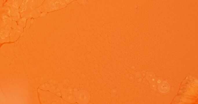 Orange flow texture background, close up. Bright orange paint moving in slow motion. Copy space in light orange pattern background. Abstract yellow color liquid. Natural flow. Colorful oil wallpaper