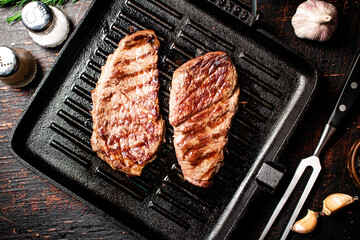 Aromatic grilled steak in a frying pan. 