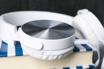 Concept of audiobook with book and headphones, close up