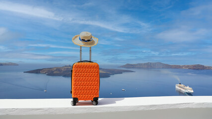 Orange luggage with hat and landscape view of Oia town in Santorini island in Greece , Greek landscape as blue sky background