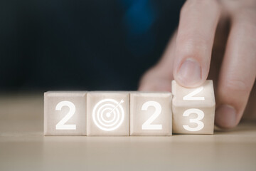 wood block cube with text 2023. Implementation of plans goals and New Year's Strategy 2023	
