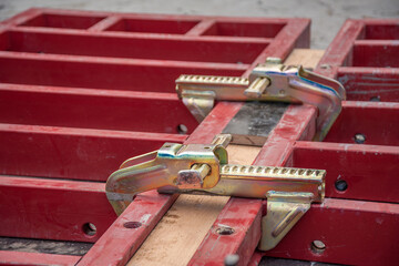 Two clamps connect formwork panels at a construction site