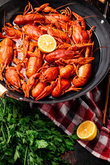 Boiled crayfish in a pot with parsley and lemon. 