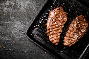 Delicious grilled steak in a frying pan. 