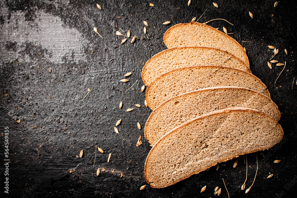 Poster Slices of rye bread with grain on the table. 