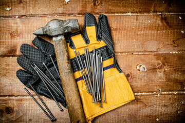 Nails with hammer and gloves. 