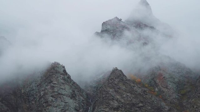 Fog around the mountain peaks during the stormy weather at Tandi in Lahaul Spiti district at Himachal Pradesh, India. Clouds rolling over the peaks of the mountain. Natural mountain background. 