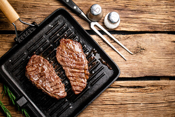 Grilled steak in a frying pan. 