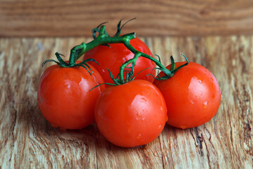 A few red tomatoes over a wooden background. Fresh vegetables.