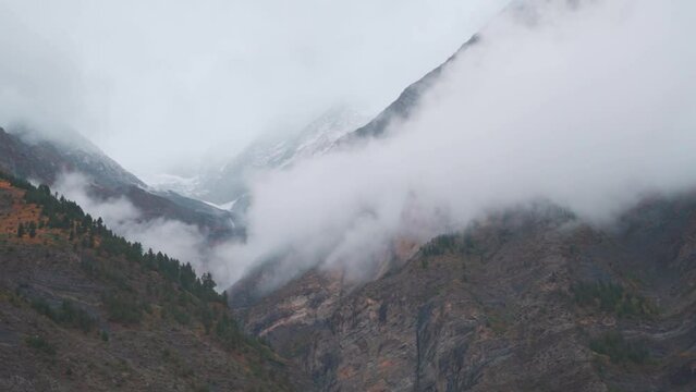 Shot of clouds above the mountain peaks during the storm at Jispa in Lahaul Spiti district at Himachal Pradesh in India. Clouds covers the peaks of the mountains. Natural background. 
