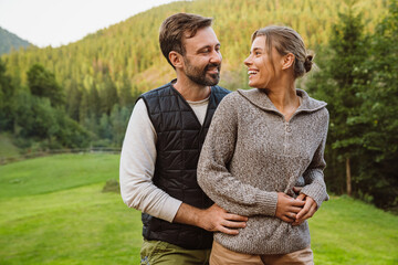 Beautiful couple hugging while standing in mountains