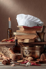 Fototapeta na wymiar Chef's hat, vintage cookbooks, and old kitchen utensils.