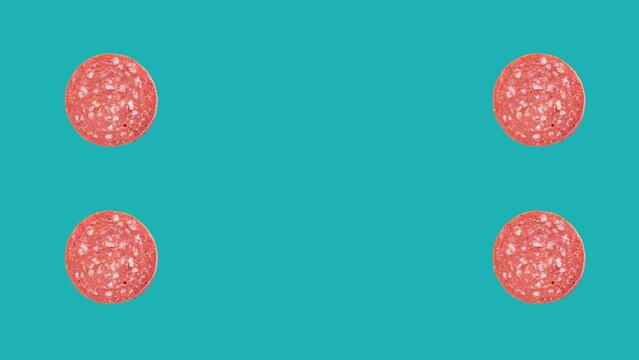 Slices of sucuk rotation on blue background with copy space. Turkish meat product sucuk.