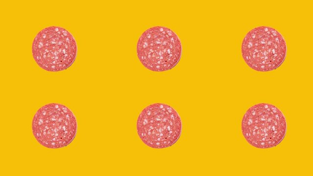 Slice of sucuk rotation on yellow background. Turkish meat product sucuk.