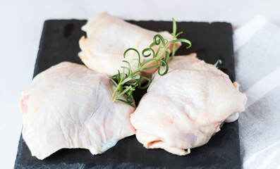 Raw chicken thighs. On a raw background. With various seasonings