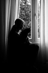 Girl sitting with cat at window silhouette - black and white photography