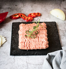 Raw minced meat with herbs and spices. on gray background