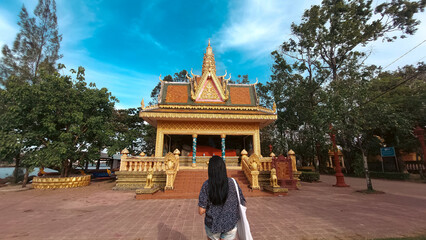 A tourist exploring Wat Traeuy Kaoh Buddhist temple on Fish Island in Kampot, Cambodia