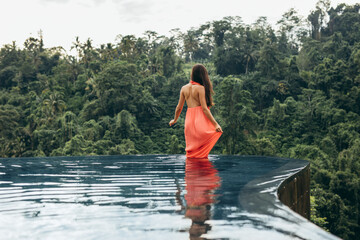 Female standing in swimming pool at luxury resort