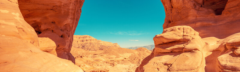 Fototapeta na wymiar Arch in the rock. Desert nature landscape. Wilderness. Timna park. Israel. Horizontal banner