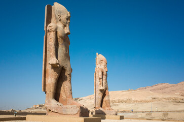 Fototapeta premium Two colossi of Amenhotep III at the northern gate of the Mortuary Temple of Amenhotep III near Luxor in Upper Egypt.