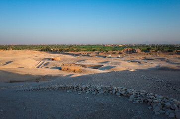 Landscape of the west bank of Nile River near Luxor, view from the archaeological site Valley of the Nobles in the Theban Necropolis on desert hills to green strip of fertile soil along the Nile