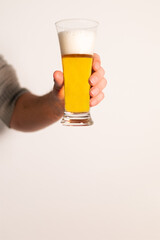 hand holding long glass of lager