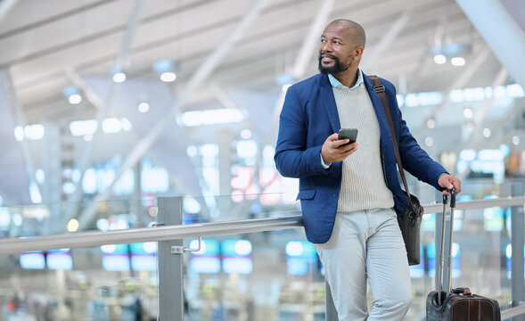 Businessman, Phone And Luggage At Airport For Travel, Journey Or Checking Flight Times Or Destinations. Happy Black Man, Person Or Employee Holding Smartphone For Schedule, Traveling Or Work Trip