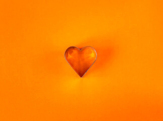 Empty orange heart shape on bright background