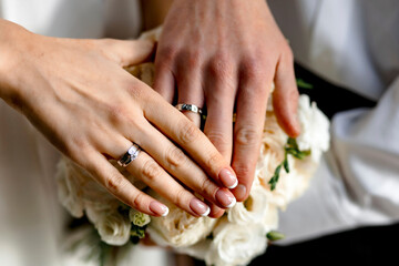 Obraz na płótnie Canvas bride and groom on a wedding bouquet. Close-up of newlyweds hands 