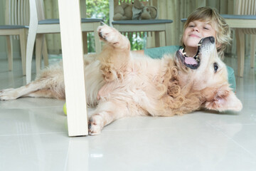 child with dog are playing under the table