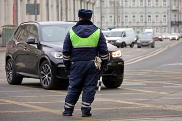 Traffic police officer standing on a road on cars background. Policeman patrol the city street