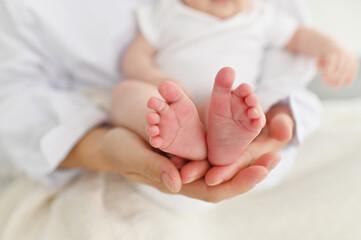Baby feet in mother hands. Mom and her Child. Happy Family concept. Beautiful conceptual image of Maternity