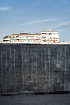 Fototapeta Wall of gray bricks in an urban landscape