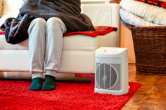 Heating season. feet in socks. woman feet with socks. Room heating with electric heater at home.