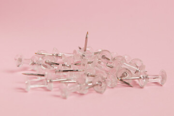Transparent push pins on paper pink background with copy space