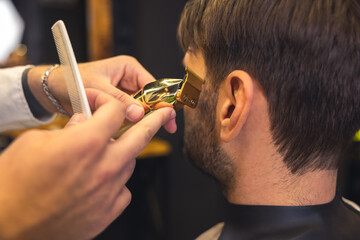 Barber carefully trimming the clients beard