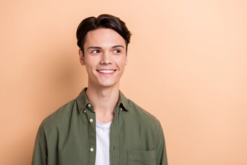 Obraz premium Photo of positive cheerful person beaming smile look interested empty space isolated on beige color background