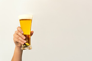 raised arm holding a glass of beer with copy space