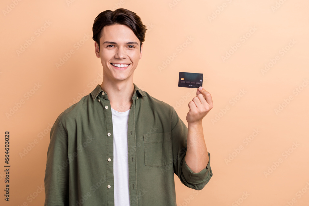 Sticker photo of nice positive person beaming smile arm hold plastic debit card isolated on beige color back